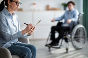 female psychologist working with handicapped adolescent in wheelchair at office