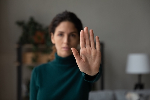 woman show no palm stop hand gesture against racial or gender discrimination