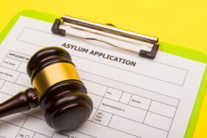 application form for asylum on a yellow background with a gavel