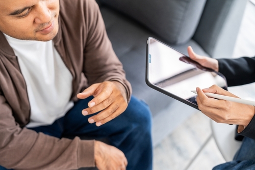 A male mental health patient consults a psychiatrist undergoing therapy and psychological assessments for effective treatment