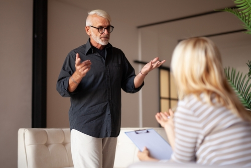 Mature refugee at a session with a psychologist. The migrant tells about his experiences and problems to the volunteer