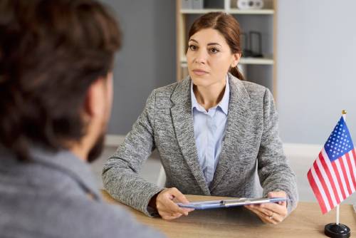 Consular visa interview with USA officer reviewing documents in public services or embassy. 